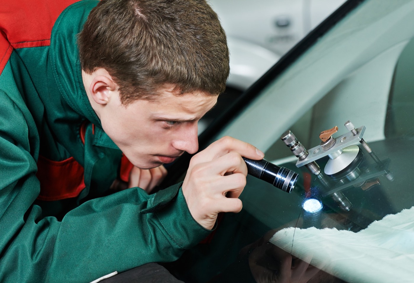 Technician repairing a long crack in a windshield